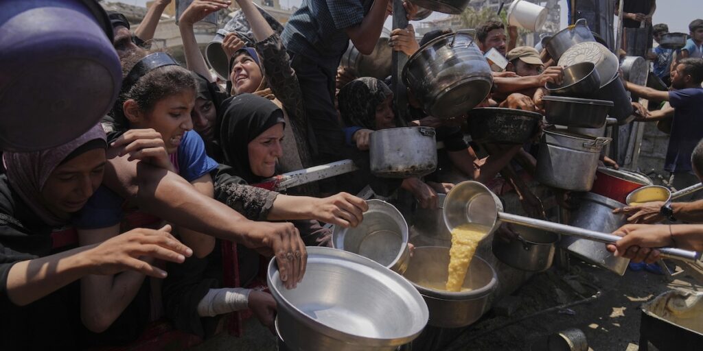 Palestinier försöker få donerad mat vid ett soppkök i Gaza City i norra Gazaremsan på lördagen. En FN-stödd organisation varnar för att ett ”värsta tänkbara scenario av svält” utvecklas i området.