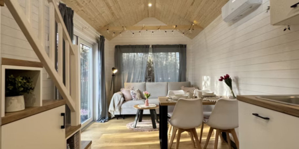 Det ljusa vardagsrummet i Smile kombinerar skandinavisk minimalism med smart planlösning och rymmer både soffa och matplats. (Foto: Vagabond Haven)