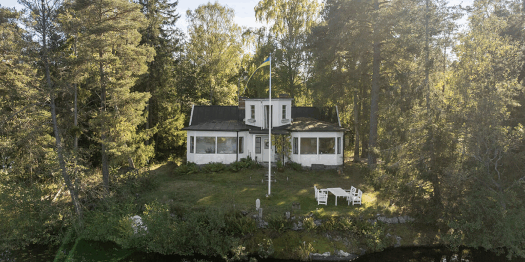 Sekelskifteshuset på Korsholmen, omgivet av vatten och lummig grönska. (Foto: Skandiamäklarna Nacka)