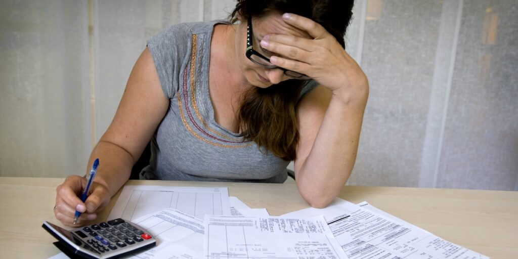 Kvinna ser stressad ut medan hon räknar räkningar inför julen.