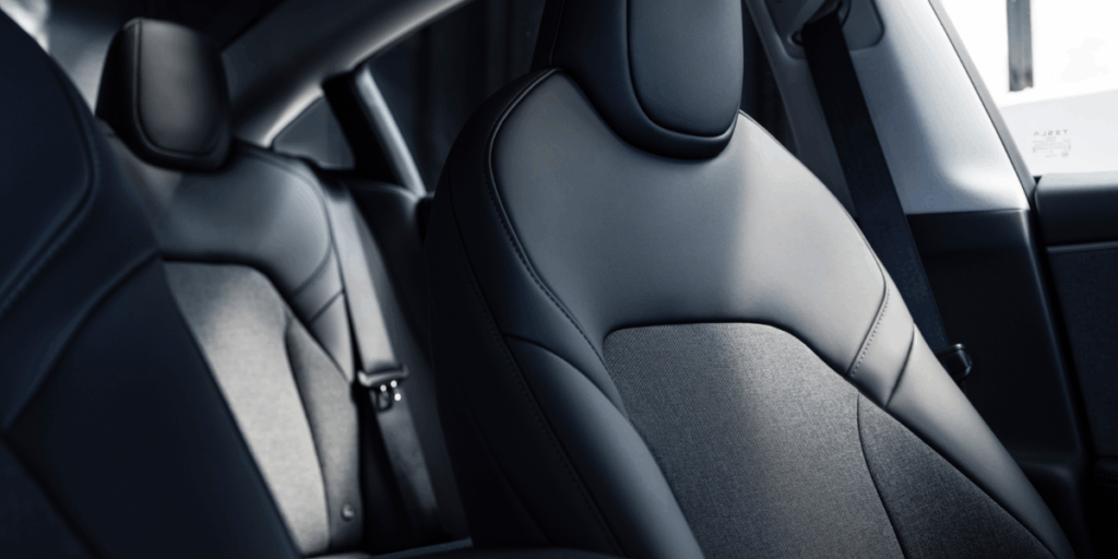 Stolar med tyg i mitten, en av sakerna som gör att bilen är lite mer prisvänlig. (Foto: Tesla)