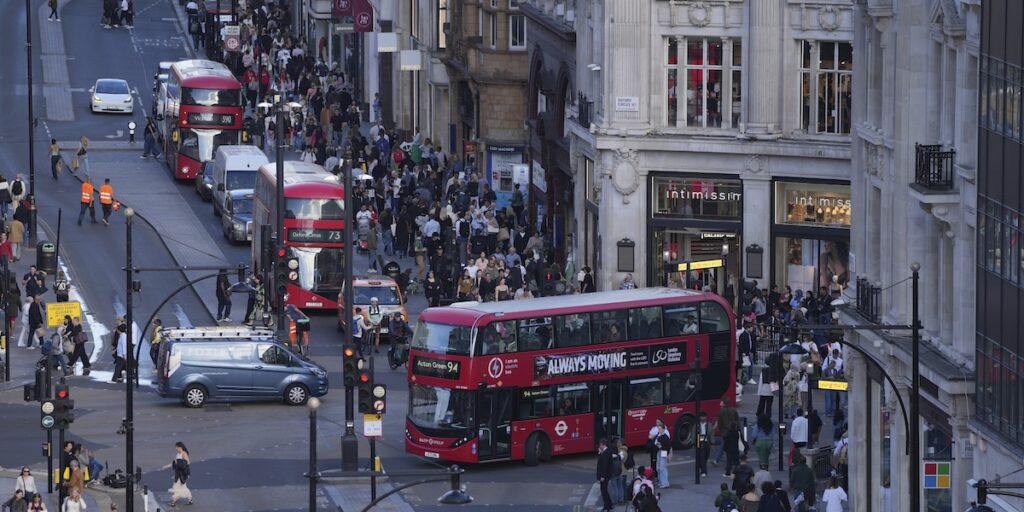 Gatuliv med bussar och folkmassor i centrala London – Storbritanniens ekonomi krympte oväntat i oktober.