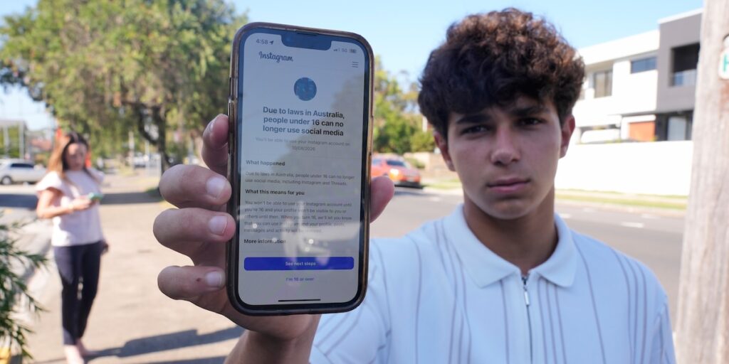 Tonåring i Australien visar ett mobilmeddelande från Instagram som förklarar att personer under 16 inte längre får använda sociala medier enligt ny lag.